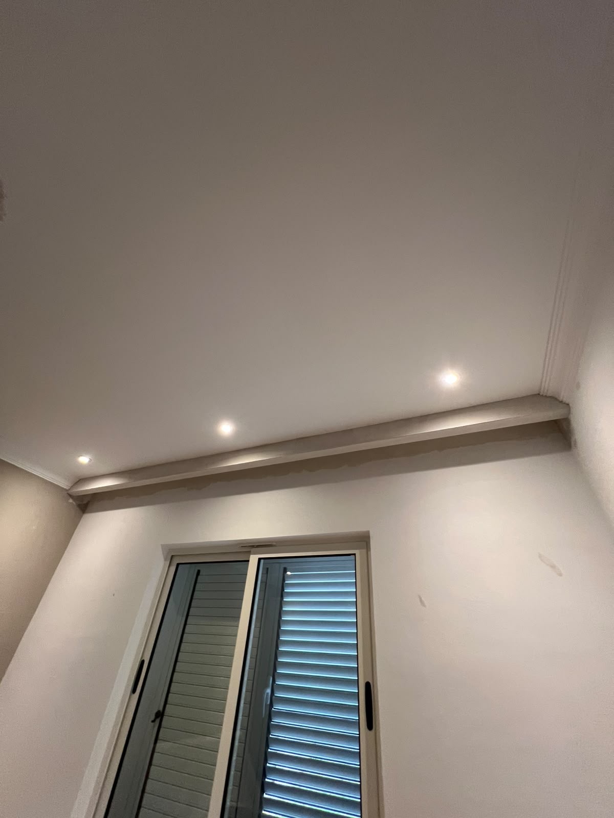 Pamje tjetër e tavanit me spote dhe element të ulur pranë dritares