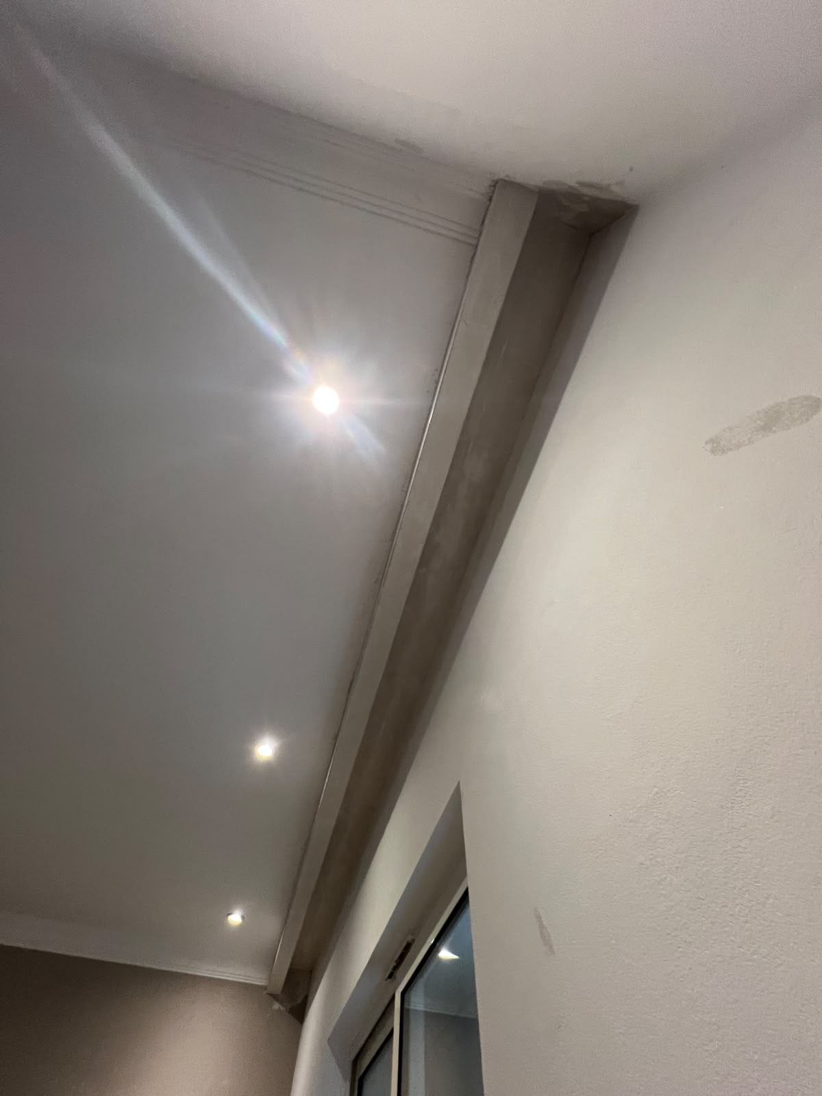 Element gjatësor i tavanit me spote, parë nga këndi i dritares